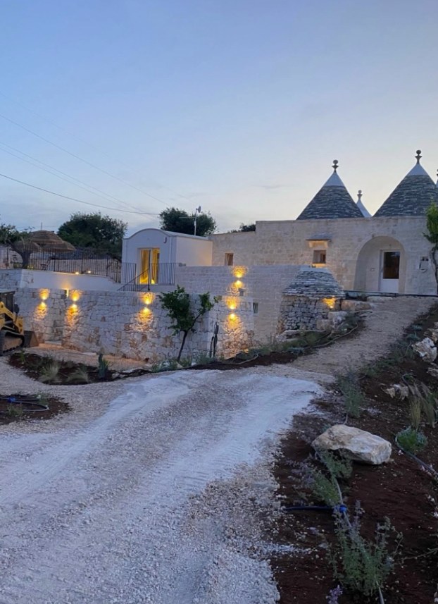 Un trullo restaurato all'imbrunire, con le luci accese
